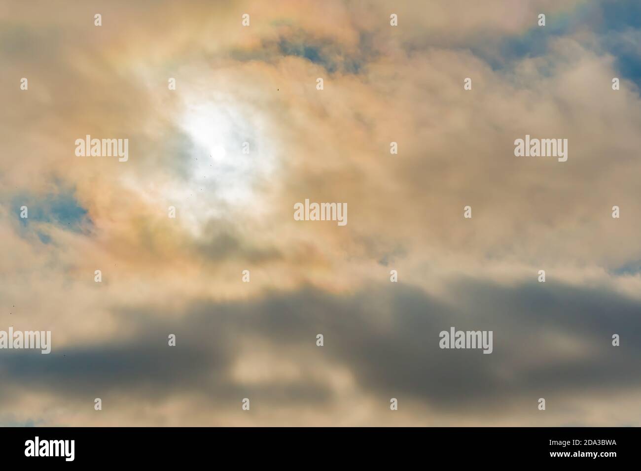 Wolkiger Himmel, Sonne hinter Wolken. Seltsame Sicht auf einen wolkigen Himmel mit den Sonnenstrahlen, die hinter den Wolken`s. Wolkiger Himmel mit blauen Flecken und die s Stockfoto